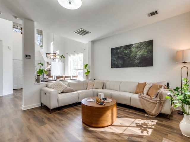 living area featuring wood finished floors, visible vents, and baseboards