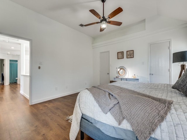 bedroom with wood finished floors, visible vents, baseboards, ceiling fan, and vaulted ceiling