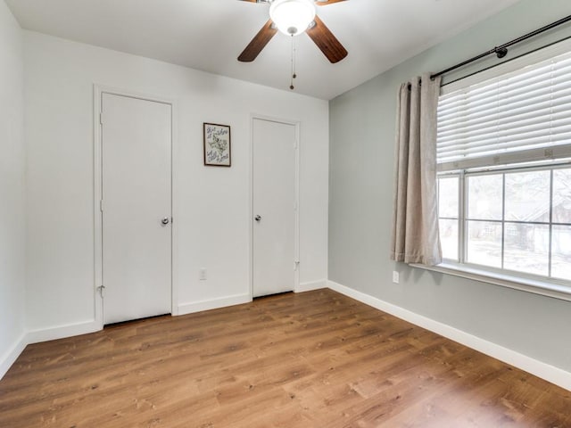 unfurnished bedroom with baseboards, ceiling fan, and light wood finished floors