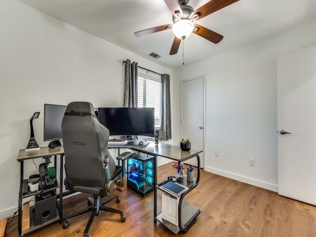 office area with visible vents, a ceiling fan, baseboards, and wood finished floors