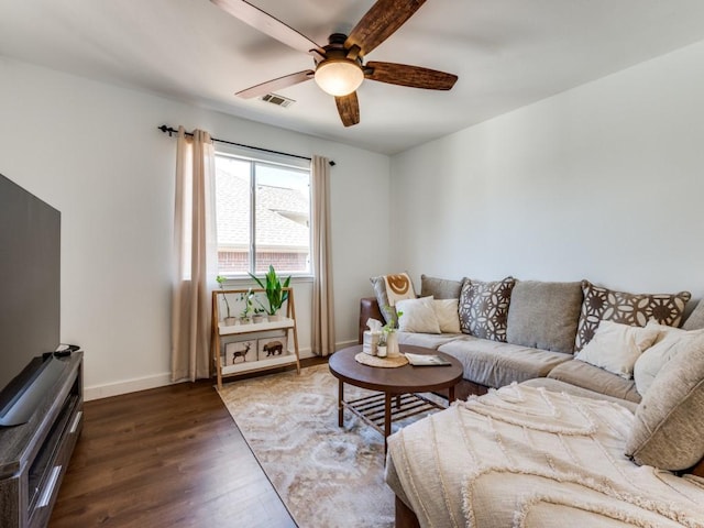 living room featuring visible vents, baseboards, wood finished floors, and a ceiling fan