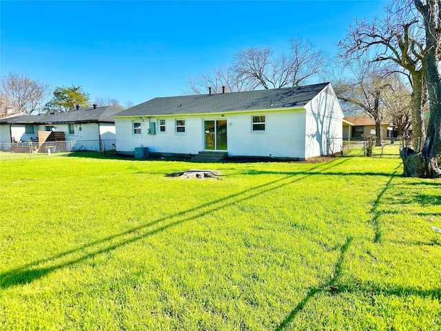 rear view of house with a gate, central air condition unit, fence, entry steps, and a yard