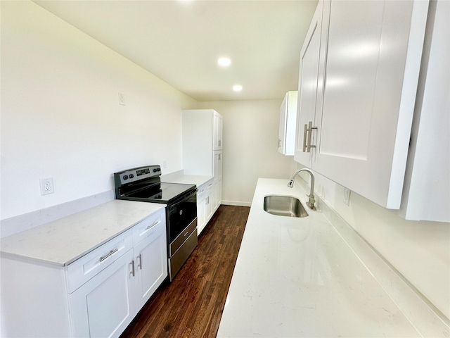 kitchen featuring dark wood-style flooring, range with electric cooktop, a sink, and white cabinetry