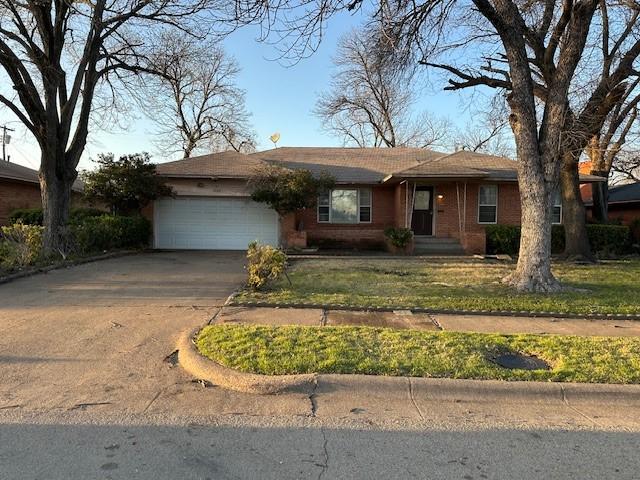 ranch-style home with a garage, brick siding, and driveway