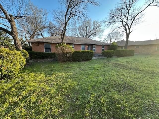 view of front of house featuring brick siding and a front lawn