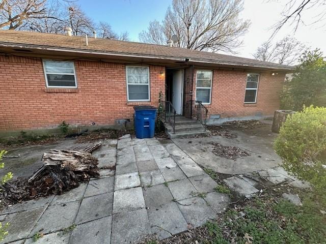 view of front of property featuring brick siding and crawl space