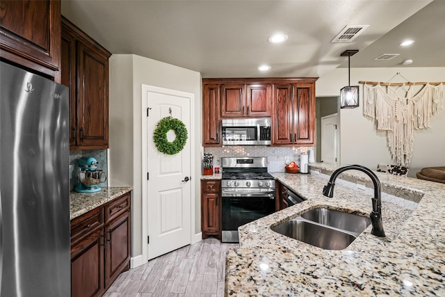 kitchen featuring visible vents, backsplash, appliances with stainless steel finishes, and a sink