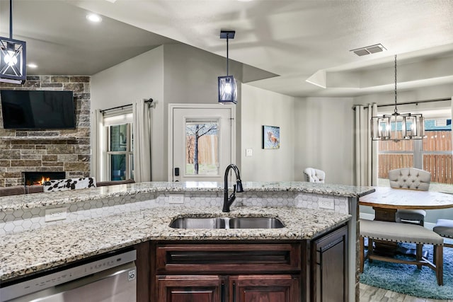 kitchen with visible vents, a fireplace, a sink, dark brown cabinetry, and stainless steel dishwasher