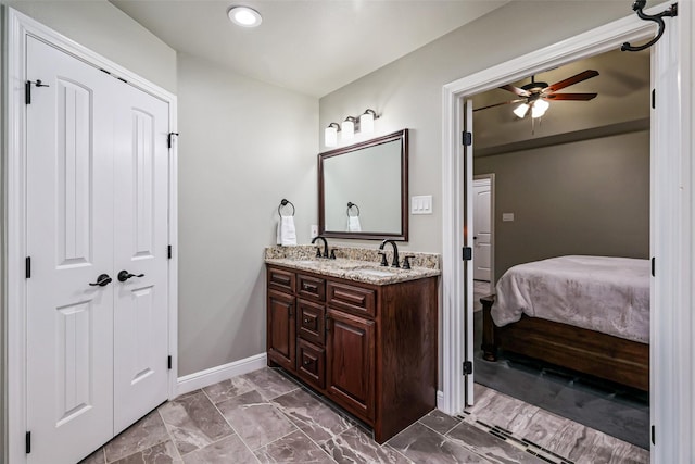 bathroom with double vanity, connected bathroom, ceiling fan, and a sink