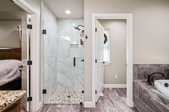 bathroom with a bath, marble finish floor, a stall shower, and baseboards