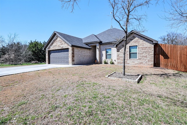 view of front of property with brick siding, a front lawn, fence, concrete driveway, and a garage