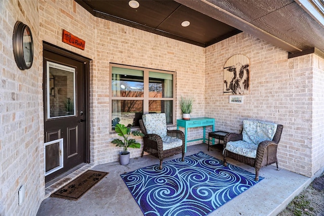 property entrance featuring brick siding and a patio area