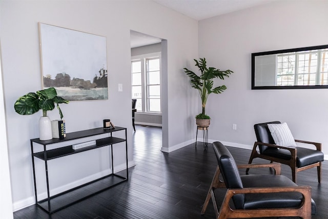 living area with dark wood-type flooring and baseboards