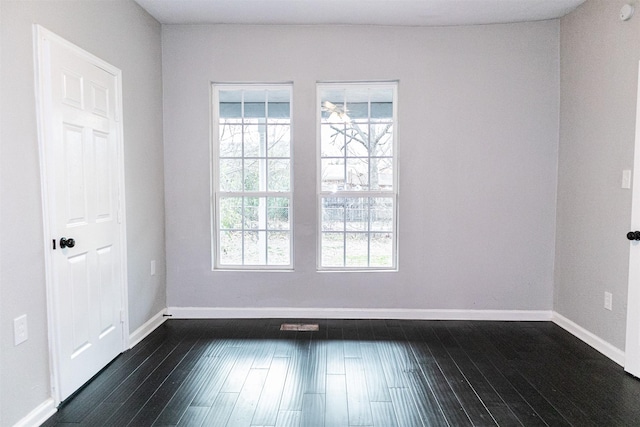 empty room with baseboards and dark wood finished floors