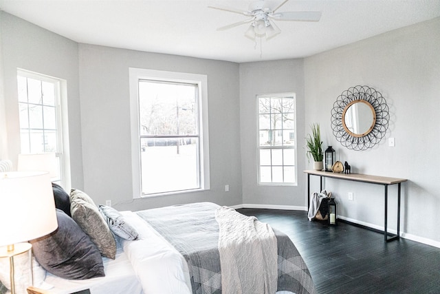 bedroom with ceiling fan, baseboards, and dark wood-style flooring