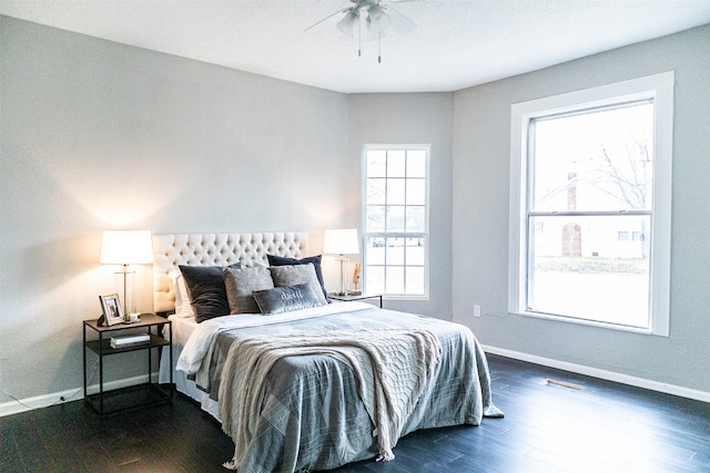 bedroom with baseboards, dark wood-type flooring, and ceiling fan