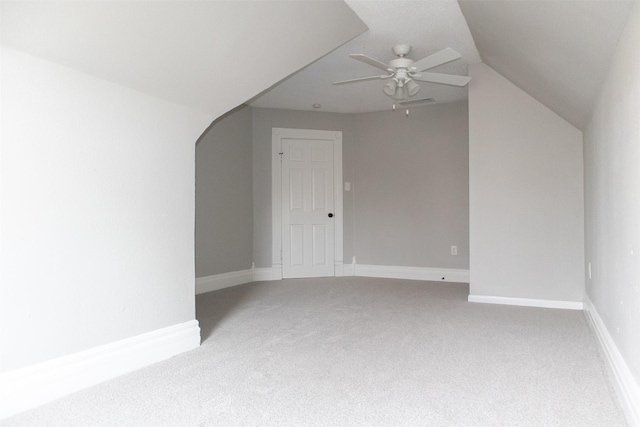 additional living space with a ceiling fan, baseboards, visible vents, lofted ceiling, and light colored carpet