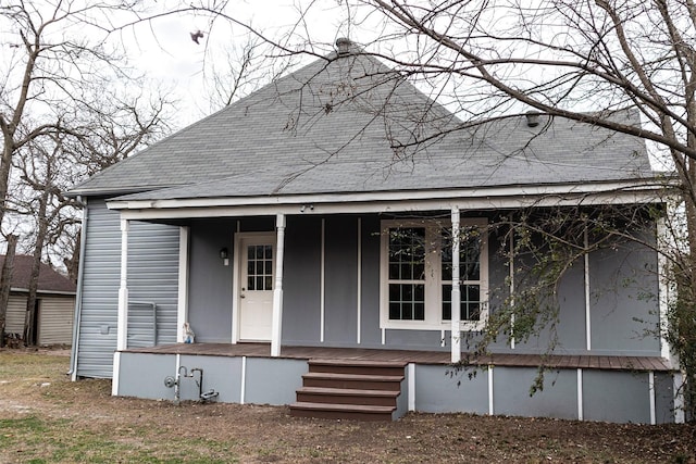 view of front of home with covered porch and roof with shingles