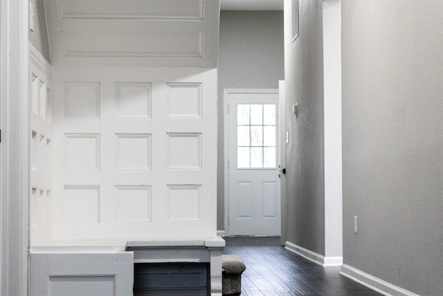 interior space featuring baseboards and dark wood-type flooring