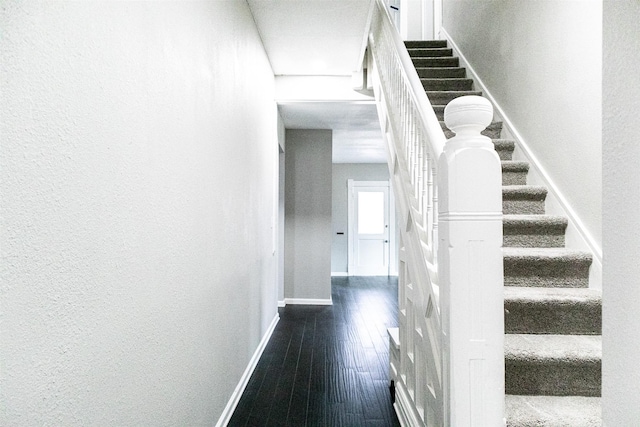 staircase with wood finished floors and baseboards