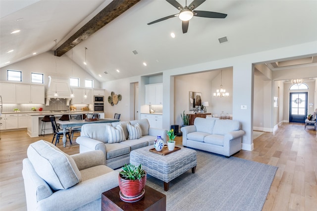 living area featuring beamed ceiling, visible vents, light wood-style flooring, and ceiling fan with notable chandelier
