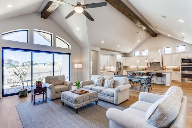 living room featuring visible vents, beam ceiling, light wood-style flooring, high vaulted ceiling, and a ceiling fan