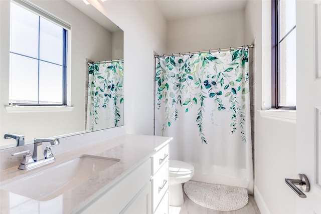 bathroom with toilet, vanity, and a shower with curtain