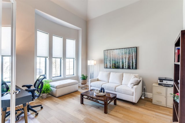 living area with a high ceiling and light wood-style flooring