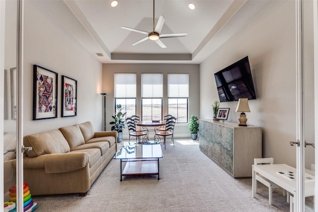 living area with visible vents, ceiling fan, light colored carpet, recessed lighting, and a tray ceiling