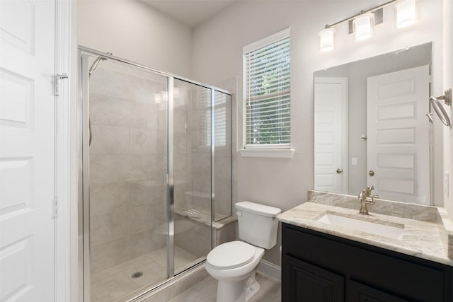 bathroom with baseboards, toilet, a stall shower, and vanity