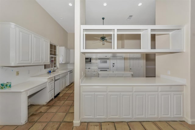 kitchen featuring a ceiling fan, a sink, light countertops, appliances with stainless steel finishes, and white cabinetry