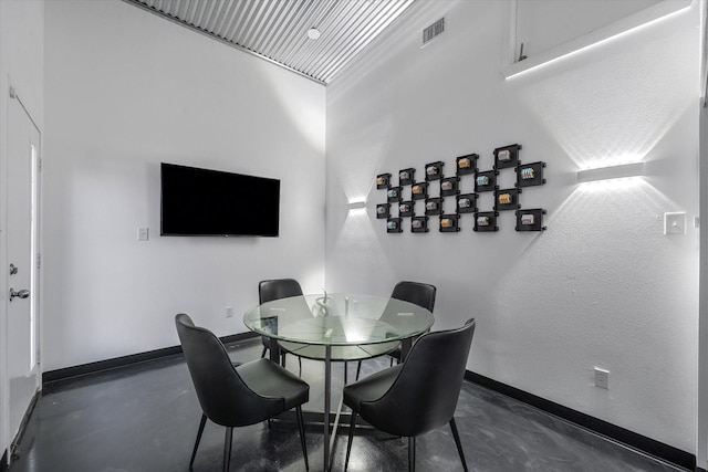 dining area with baseboards, visible vents, and concrete flooring