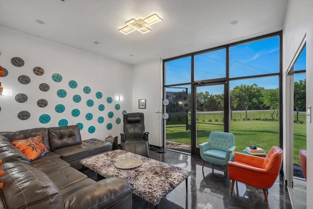 living room with a wall of windows, finished concrete flooring, and a sunroom