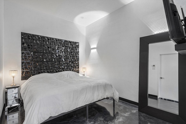 bedroom with finished concrete flooring and baseboards