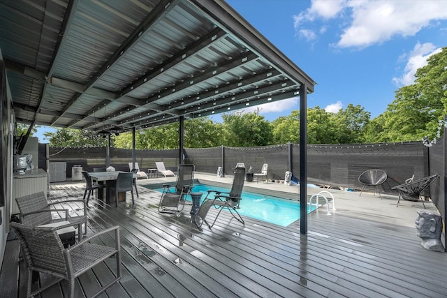 exterior space with a fenced in pool, a wooden deck, and a fenced backyard