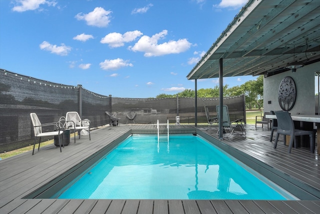 view of pool featuring a deck, outdoor dining area, a fenced backyard, and a fenced in pool