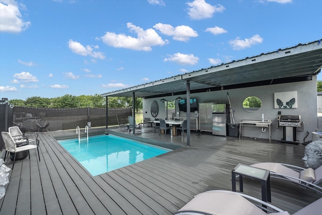 view of swimming pool with grilling area, a fenced in pool, fence, and a wooden deck