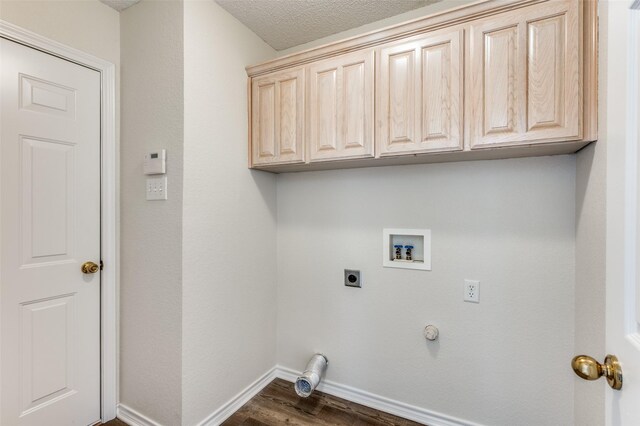 laundry room featuring electric dryer hookup, washer hookup, dark wood-style floors, cabinet space, and baseboards