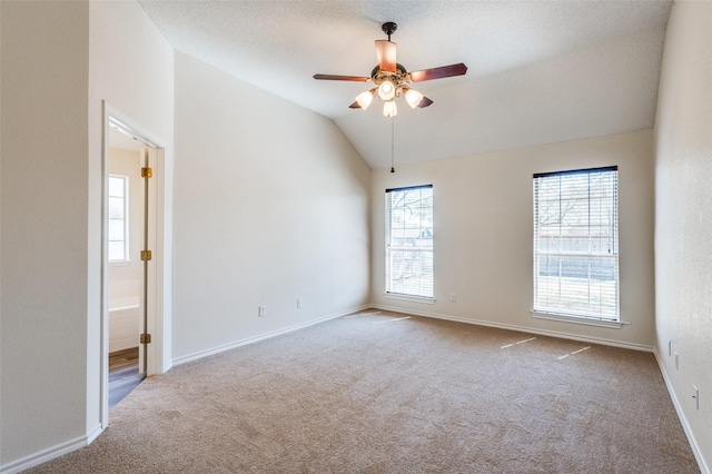 empty room featuring ceiling fan, baseboards, carpet, and vaulted ceiling