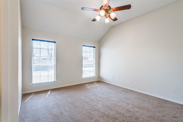 spare room featuring baseboards, lofted ceiling, a ceiling fan, and carpet flooring