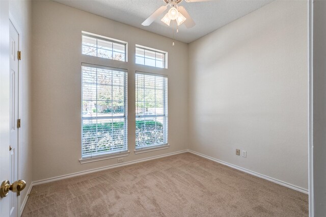 unfurnished room featuring baseboards, carpet, a ceiling fan, and a textured ceiling