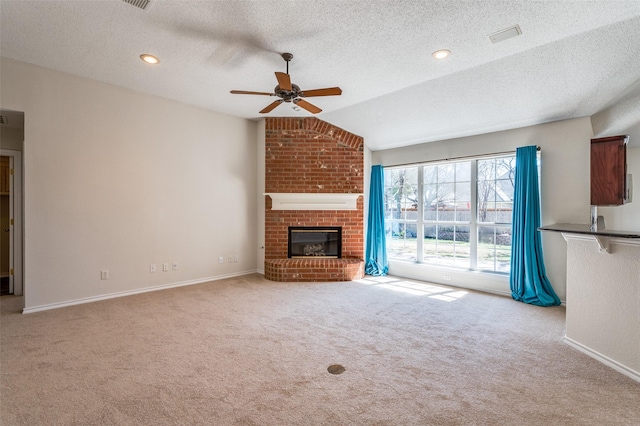 unfurnished living room with a ceiling fan, baseboards, lofted ceiling, a fireplace, and carpet flooring