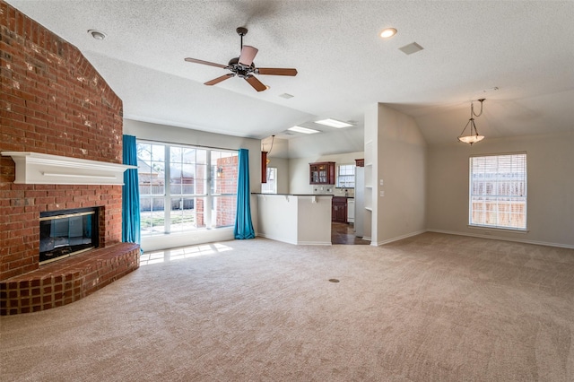 unfurnished living room with vaulted ceiling, a brick fireplace, carpet flooring, and baseboards