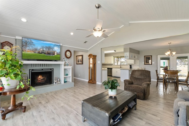 living area featuring vaulted ceiling, a healthy amount of sunlight, and light wood-style floors