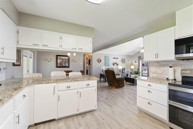 kitchen with white cabinets, backsplash, and stainless steel appliances