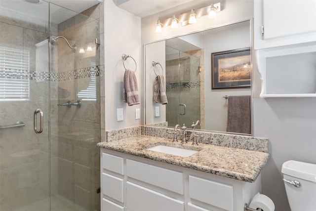 full bathroom with toilet, a stall shower, and vanity