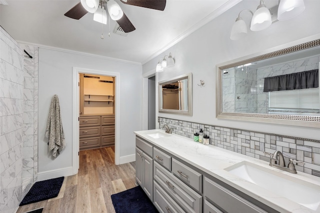 bathroom with crown molding, wood finished floors, tasteful backsplash, and a sink