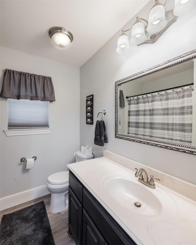 full bath with a shower with curtain, toilet, wood finished floors, baseboards, and vanity
