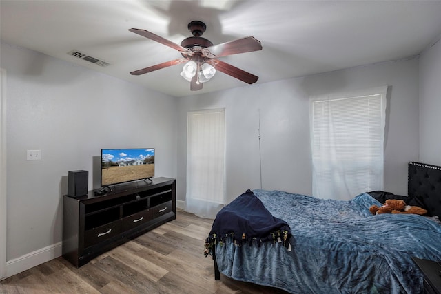 bedroom with visible vents, baseboards, ceiling fan, and light wood finished floors