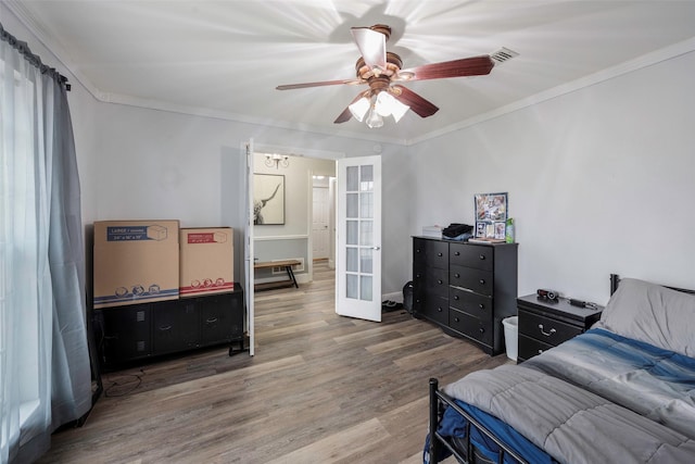 bedroom featuring ceiling fan, french doors, wood finished floors, and ornamental molding